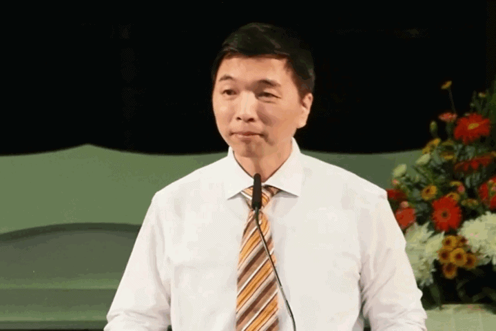 Serious man speaking at Fairfield Methodist Church pulpit during sermon.