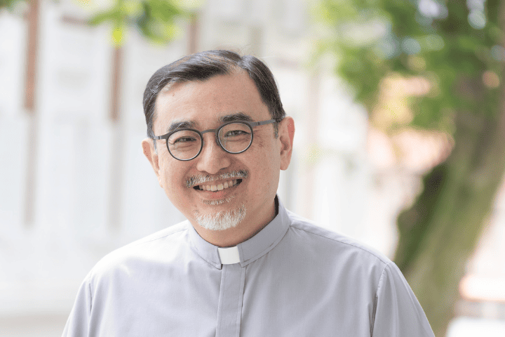 Man pastor smiling outdoor at Fairfield Methodist Church, Singapore, clergy in clergy shirt.