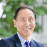 Smiling man in business suit outdoor Fairfield Methodist Church Singapore Faith community worship leader.