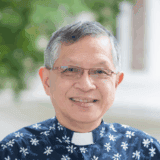 Clergy member in church attire outside Fairfield Methodist Church, Singapore.