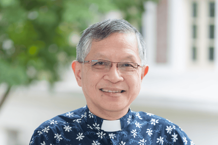 Clergy member in church attire outside Fairfield Methodist Church, Singapore.