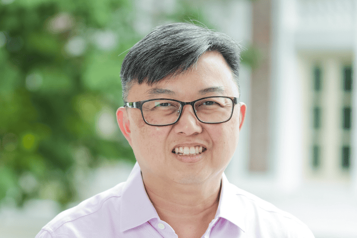Senior man smiling outdoors at Fairfield Methodist Church Singapore.